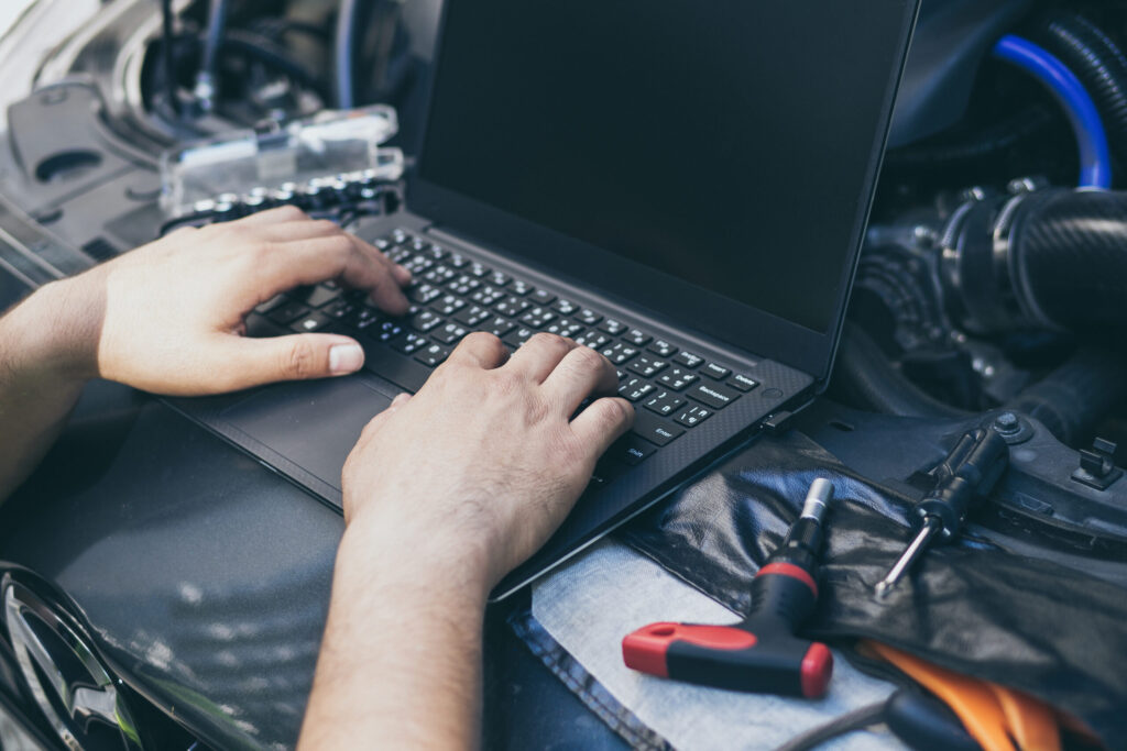 Close up engineer mechanic using electrnoic diagnostic equipment to tune a cars ecu